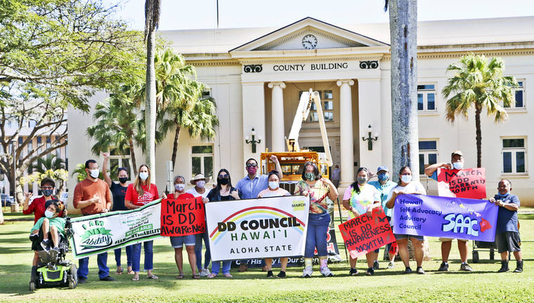 DD Council and SAAC group photo holding banners in front of a county building